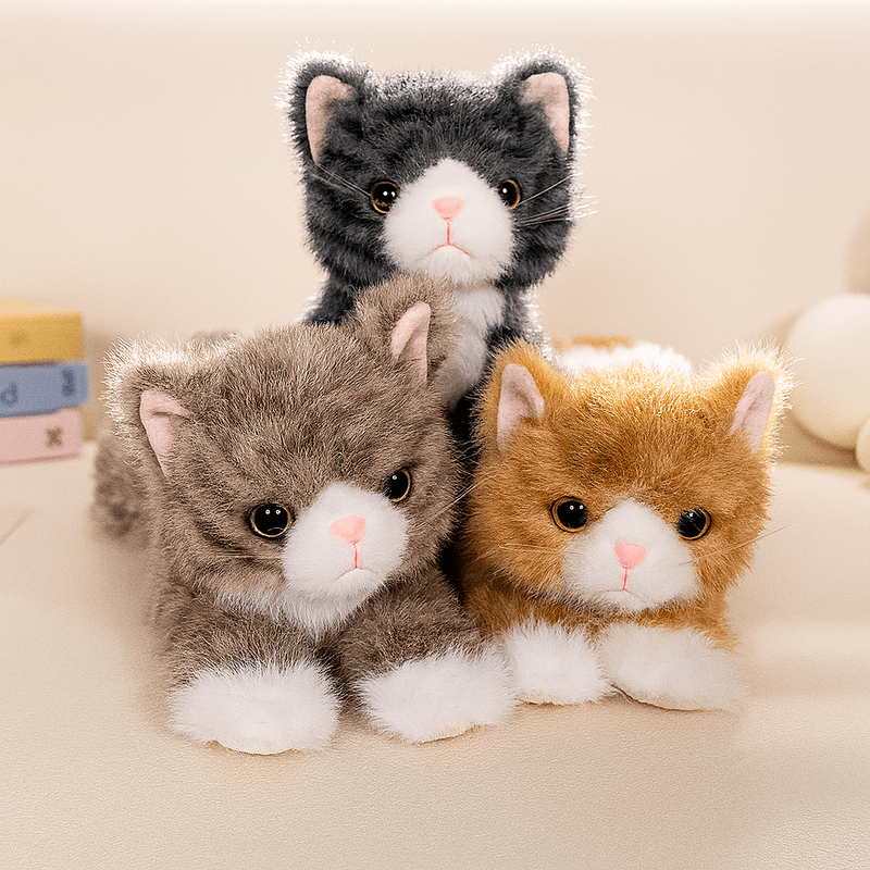 Trois grandes peluches de chats réaliste sur un canapé