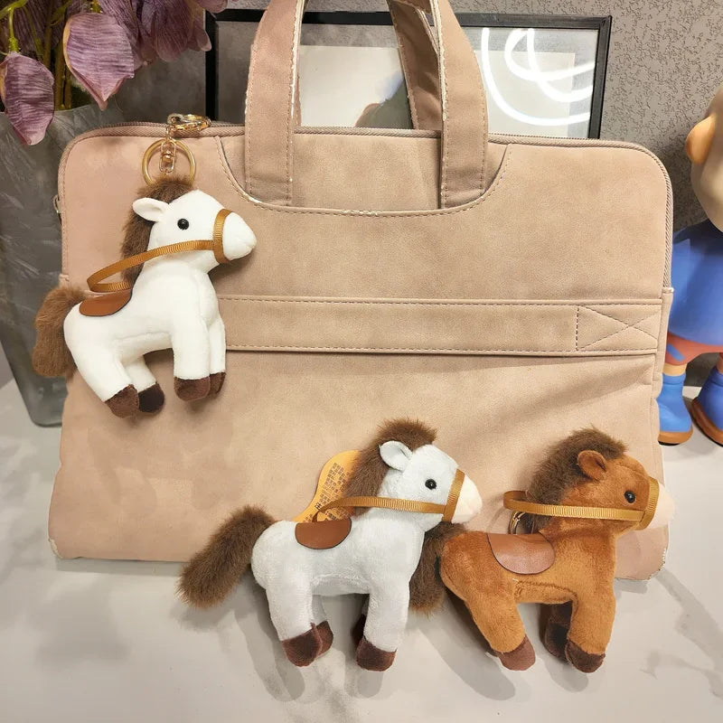 Trois mini cheval couché sur un sac à main dont un accroché avec un crochet