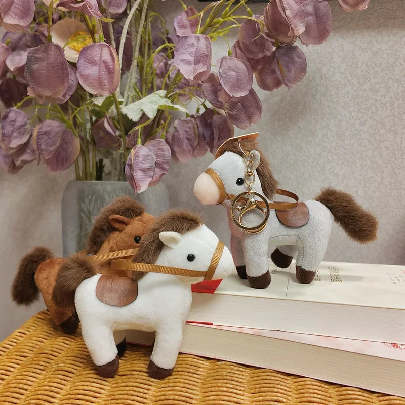 Trois mini peluches cheval sur une chaise en osier dont un sur deux livres 