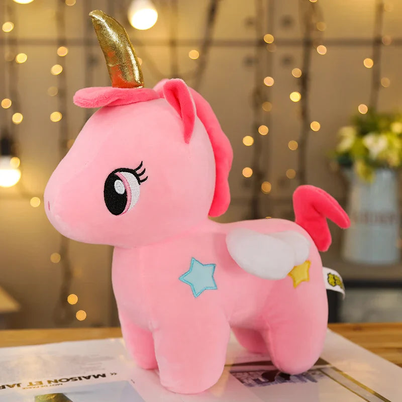 Mini peluche  licorne rose dorée sur une table