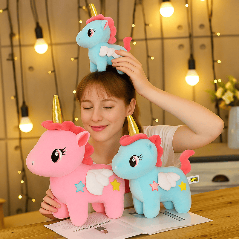 Trois minis peluches licornes dorées sur une table avec une fille Image