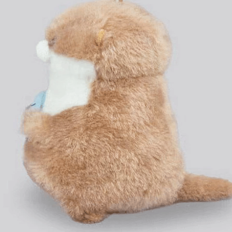 Mini peluche loutre avec son poisson de profil sur un fond gris