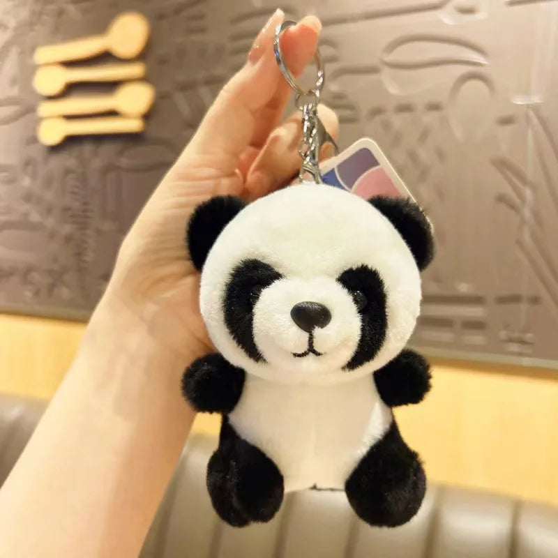 Mini peluche panda tenue par la main d'une fille Image