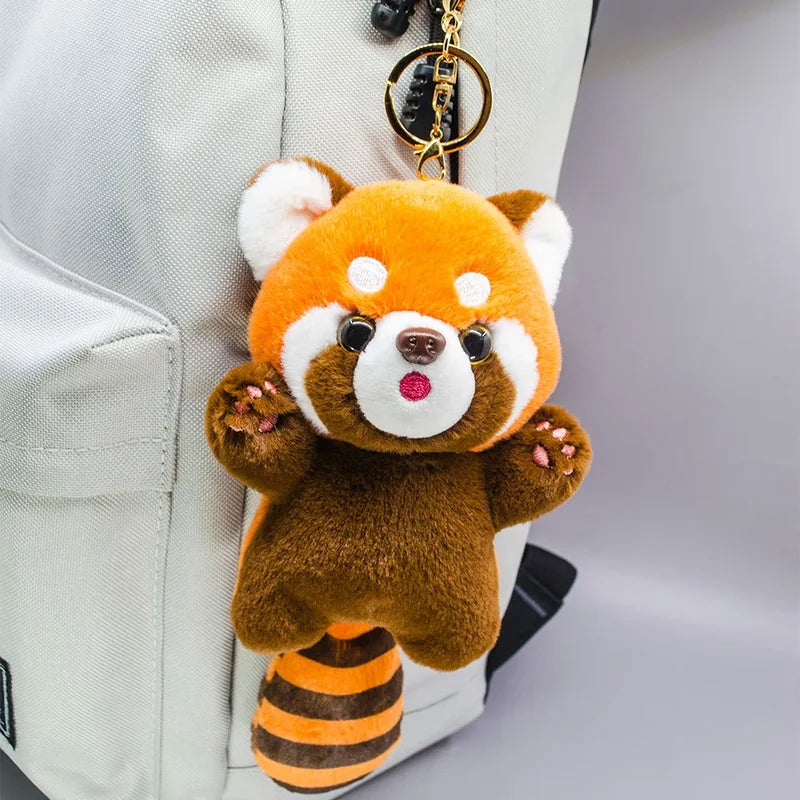 Mini peluche panda roux accroché à un sac à dos