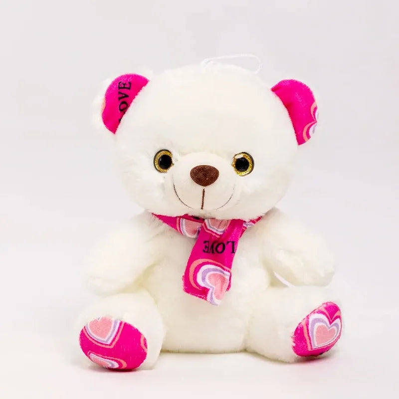 Ours rose en peluche à l’écharpe douce sur un fond blanc