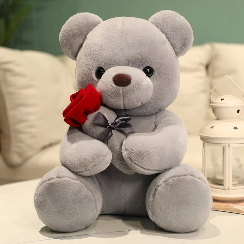 Ours gris en peluche avec une rose sur un canapé