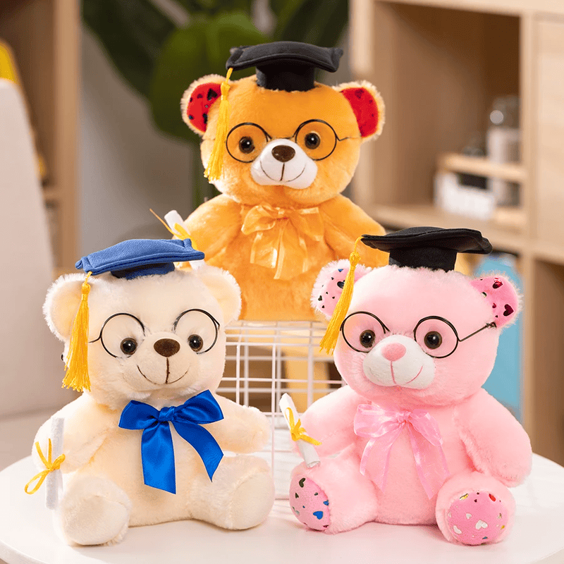 Trois peluches ours diplômés sur une table blanche Image
