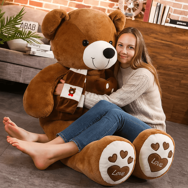 Ours marron en peluche géant avec une fille sur les genoux
