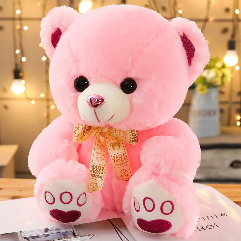 Ours rose mignon avec son ruban doré sur une table
