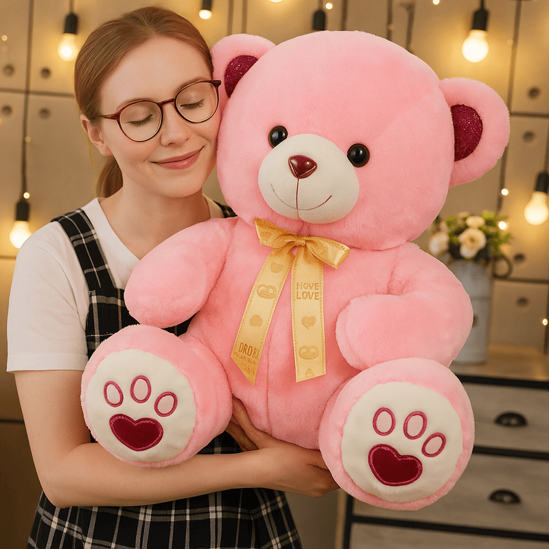Ours rose mignon avec son ruban doré dans les bras d'une fille