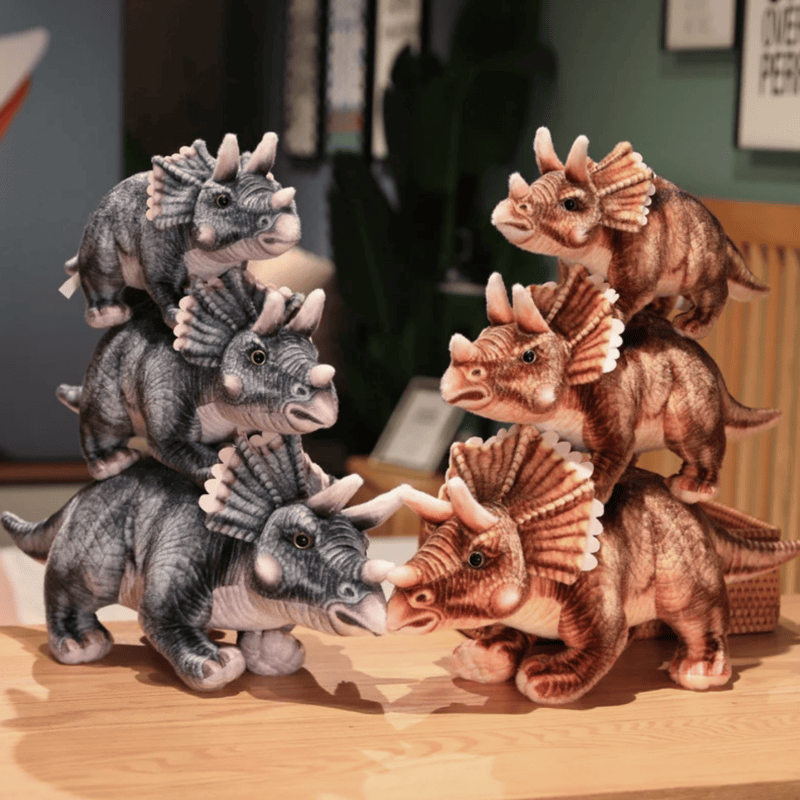 Six peluches tricératops réaliste sur un meuble