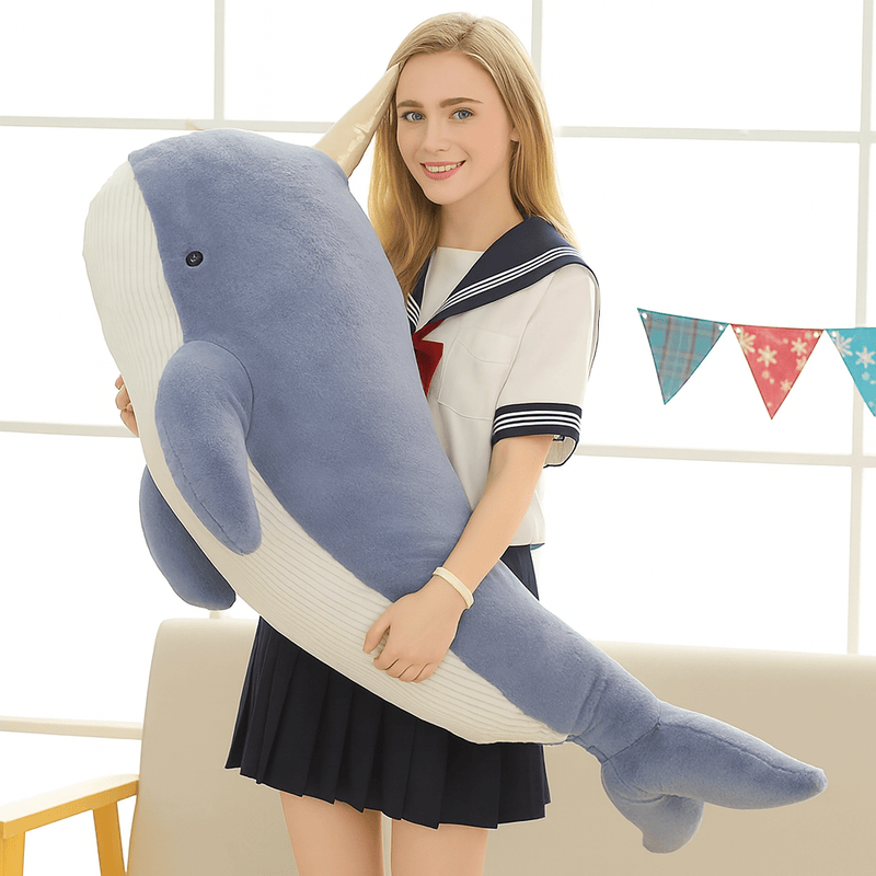 Peluche baleine licorne bleu xxl dans les bras d'une fille