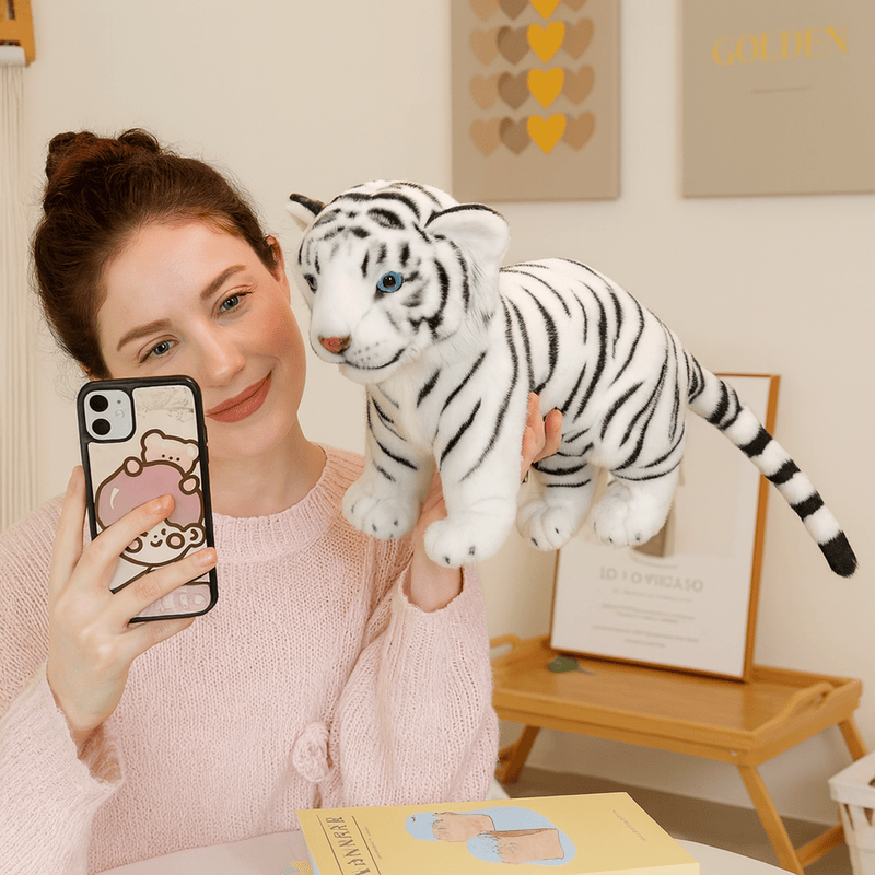 Peluche bébé tigre blanc douce tenu par une main par une fille Image