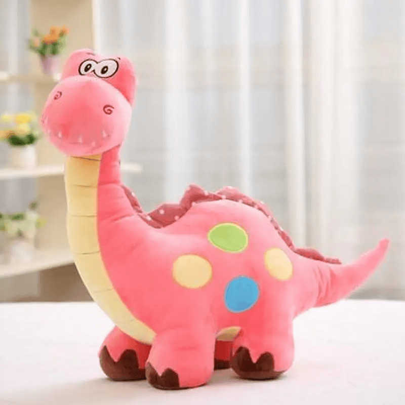 Peluche brontosaure rose sur un meuble blanc