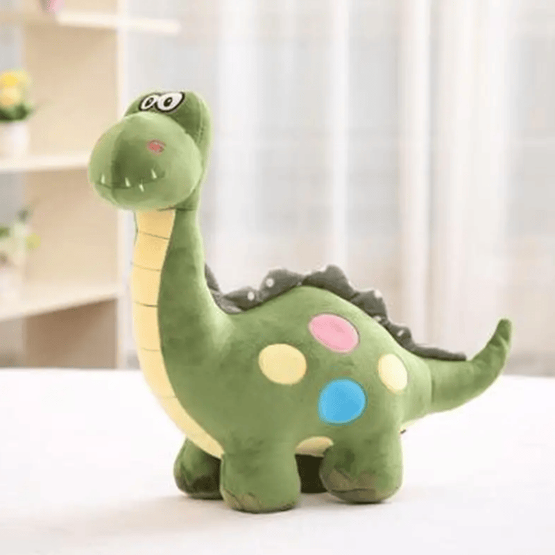 Peluche brontosaure vert sur un meuble blanc