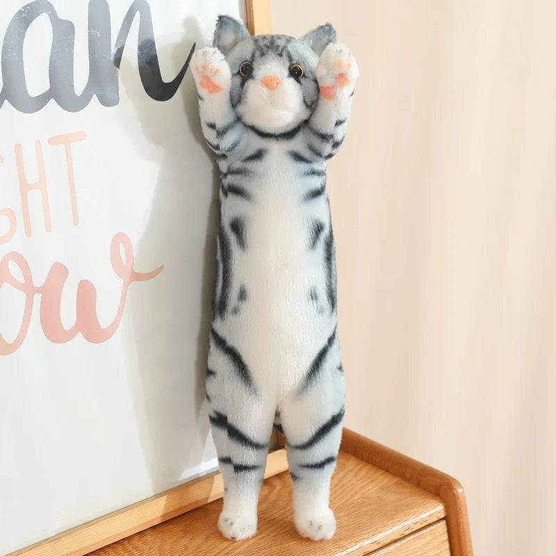 Peluche chat gris argenté debout sur un meuble