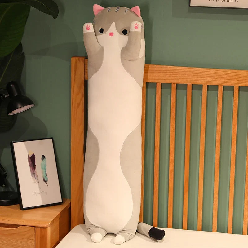 Peluche chat gris long sur un lit