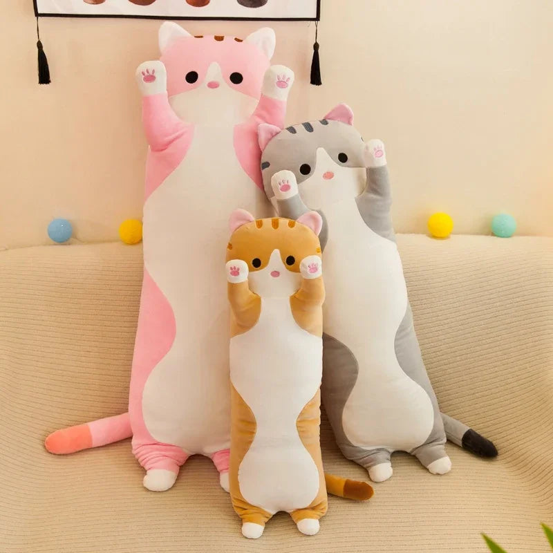 Trois peluches chats long sur un canapé