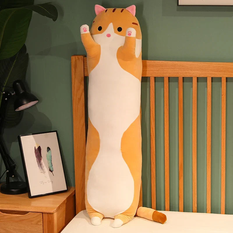 Peluche chat long roux sur un lit