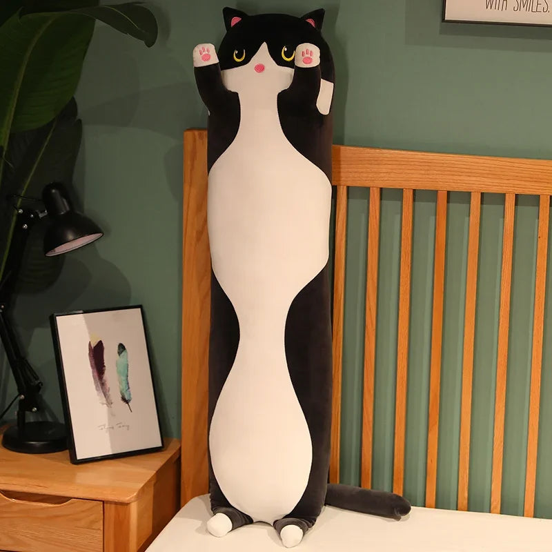 Peluche chat long noir sur un lit