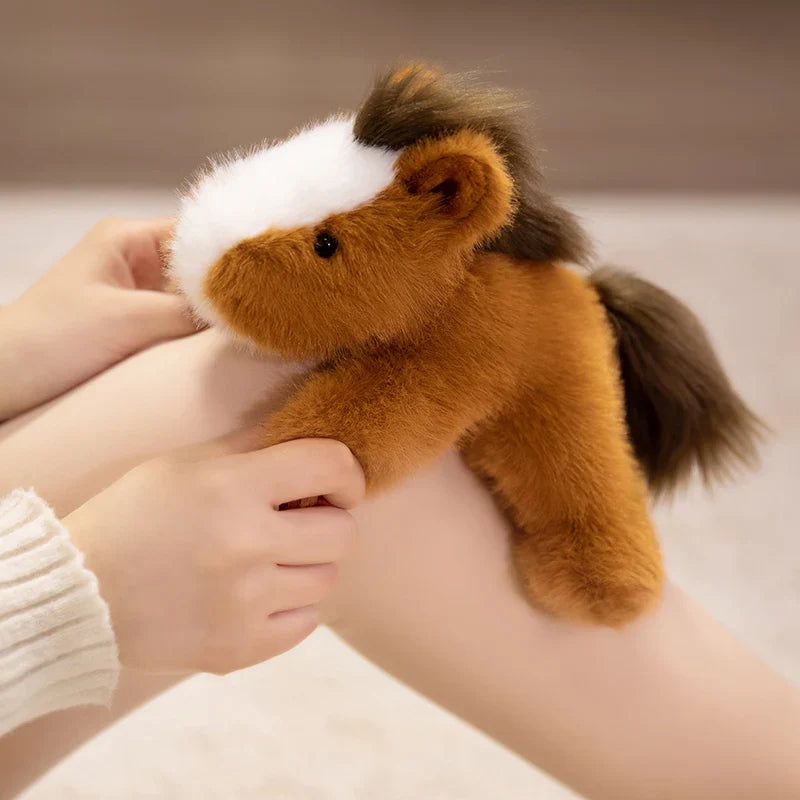 Peluche cheval couché marron clair sur le genou d'une fille
