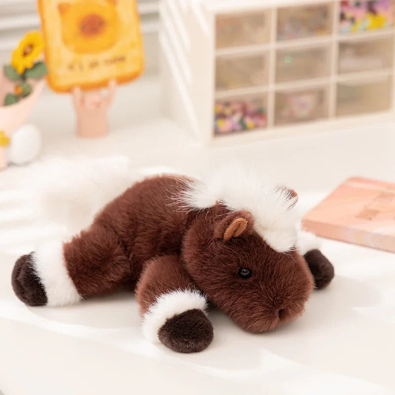 Peluche cheval couché brun sur le sol