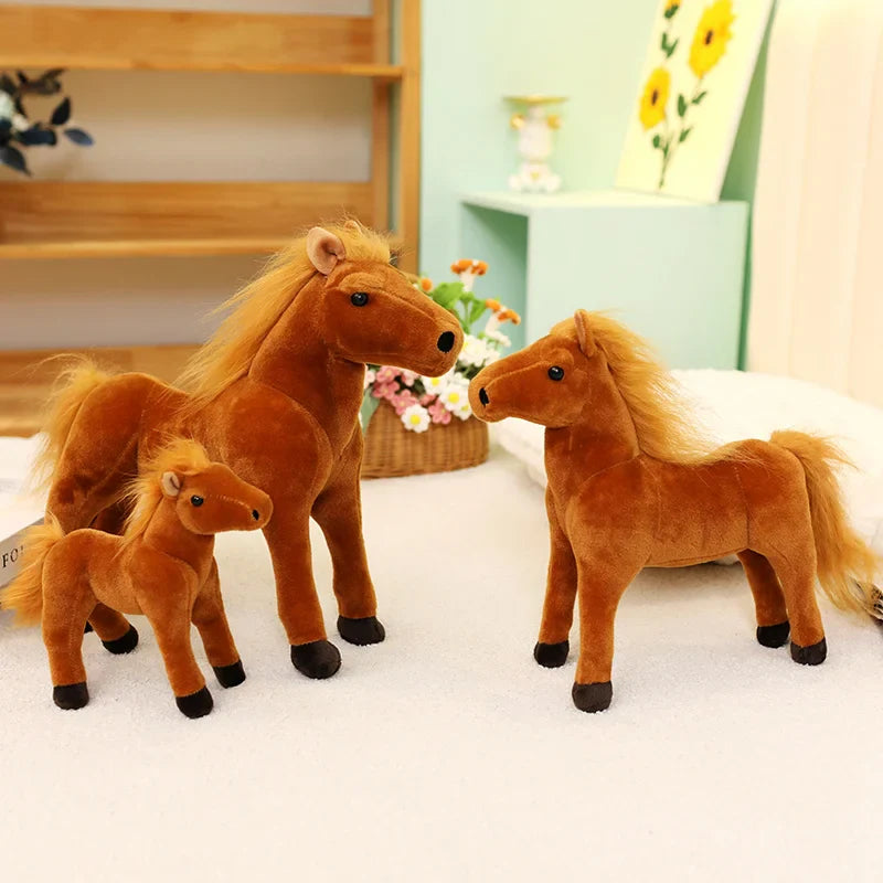 Trois peluches chevaux doux de trois tailles différentes sur un tapis