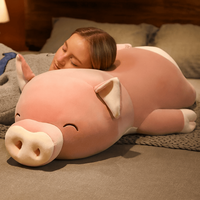 Peluche cochon smile sur un lit avec une fille endormi dessus Image
