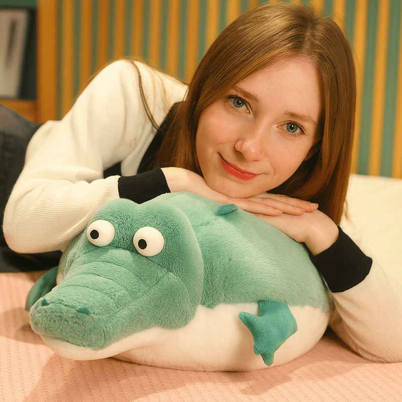 Peluche crocodile cartoon écrasé par une fille ayant les mains et la tête dessus Image