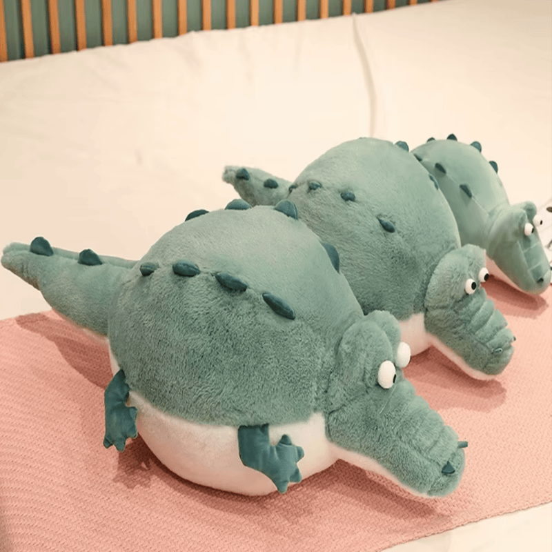 Trois peluches crocodiles cartoon sur un lit Image