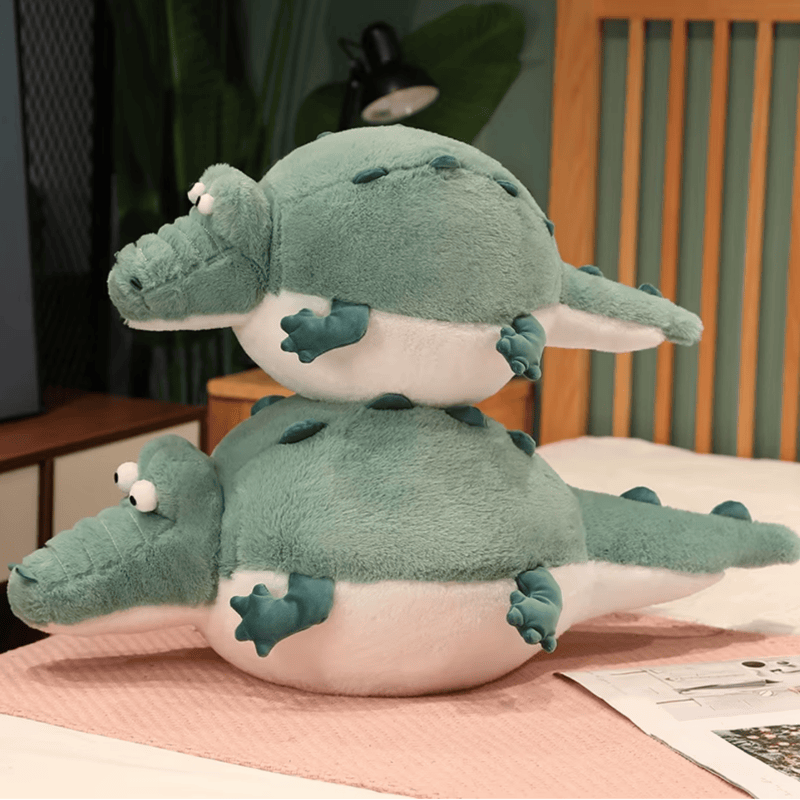Deux peluches crocodiles cartoon sur un lit l'un sur l'autre