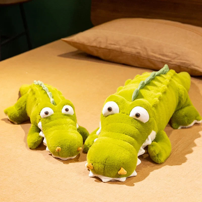 Deux peluches crocodile rigolo aux gros yeux sur un lit