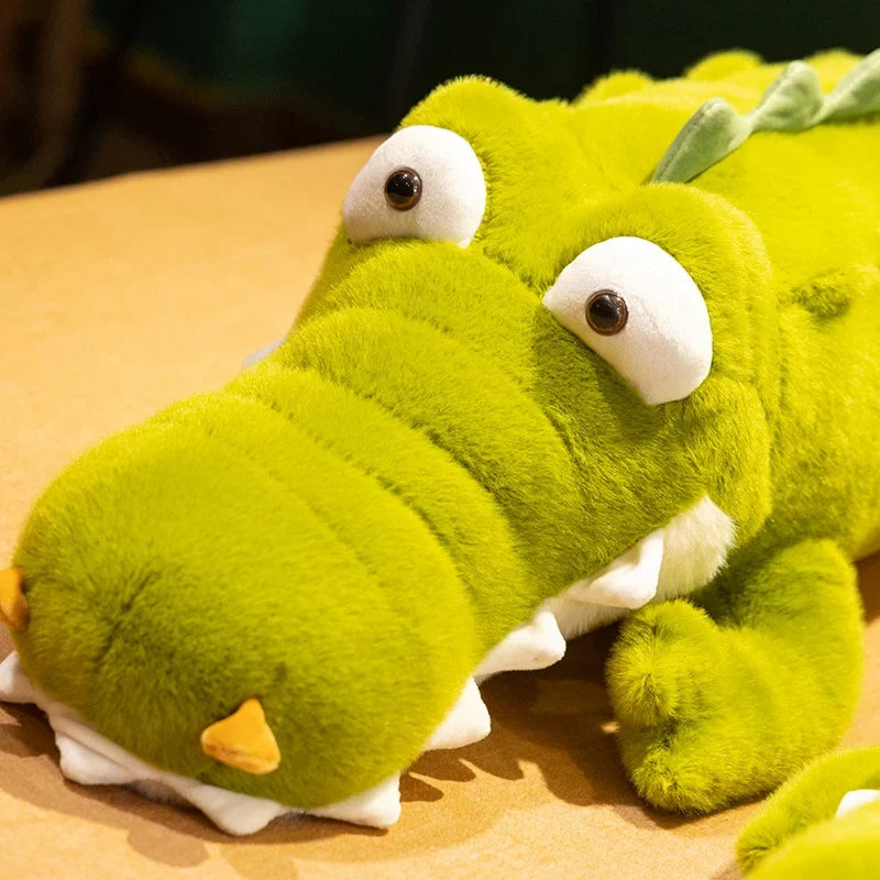 Zoom sur la tête de la peluche crocodile rigolo aux gros yeux sur un lit