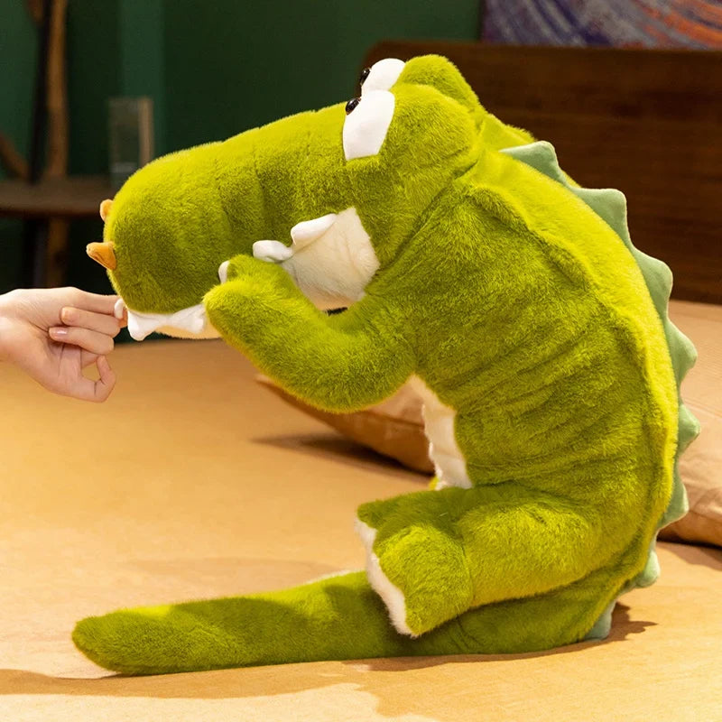 Peluche crocodile rigolo aux gros yeux enroulé debout sur le lit Image
