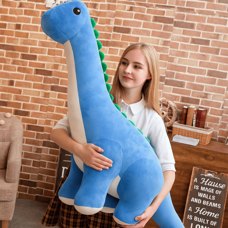 Peluche diplodocus bleue réaliste dans les bras d'une fille