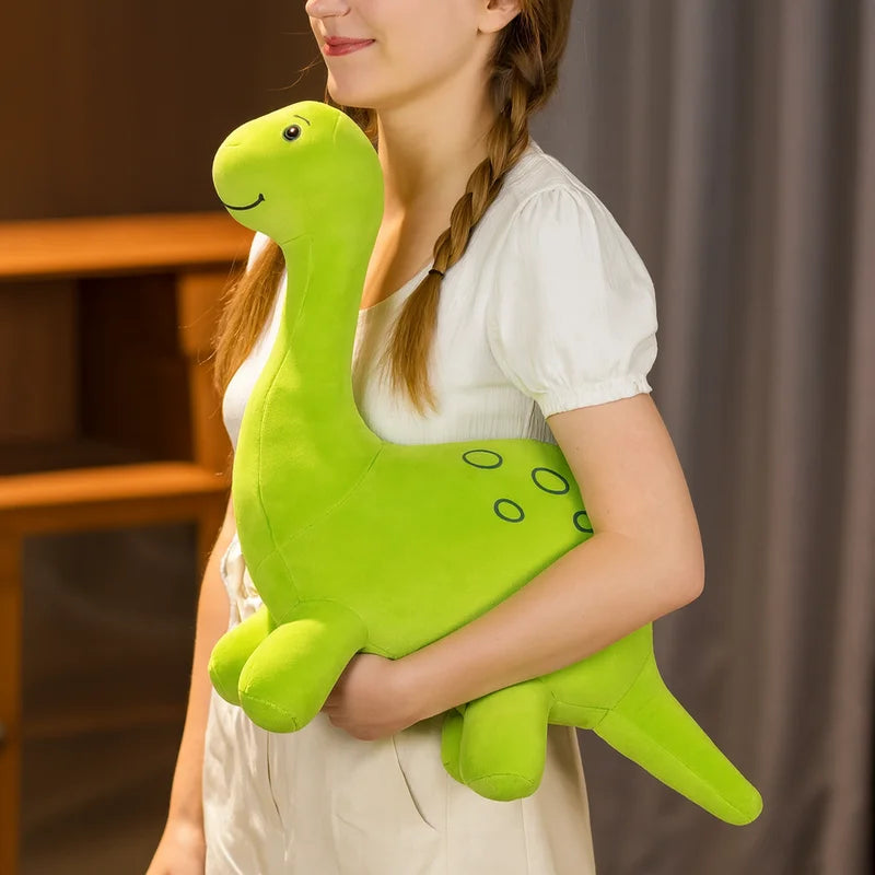 Peluche diplodocus verte tenue par une fille
