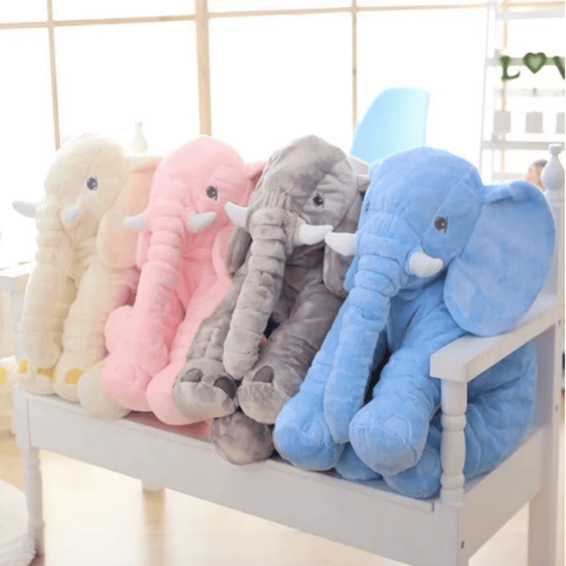 Peluches éléphants jaune, rose, gris, bleu sur un banc d'enfant Image