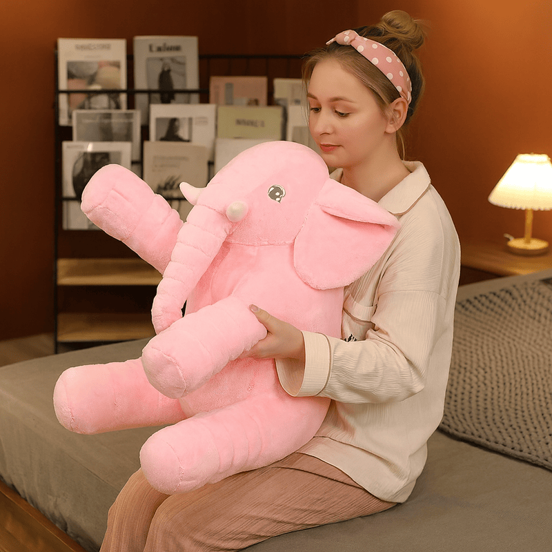 Peluche éléphant rose sur les genoux d'une fille