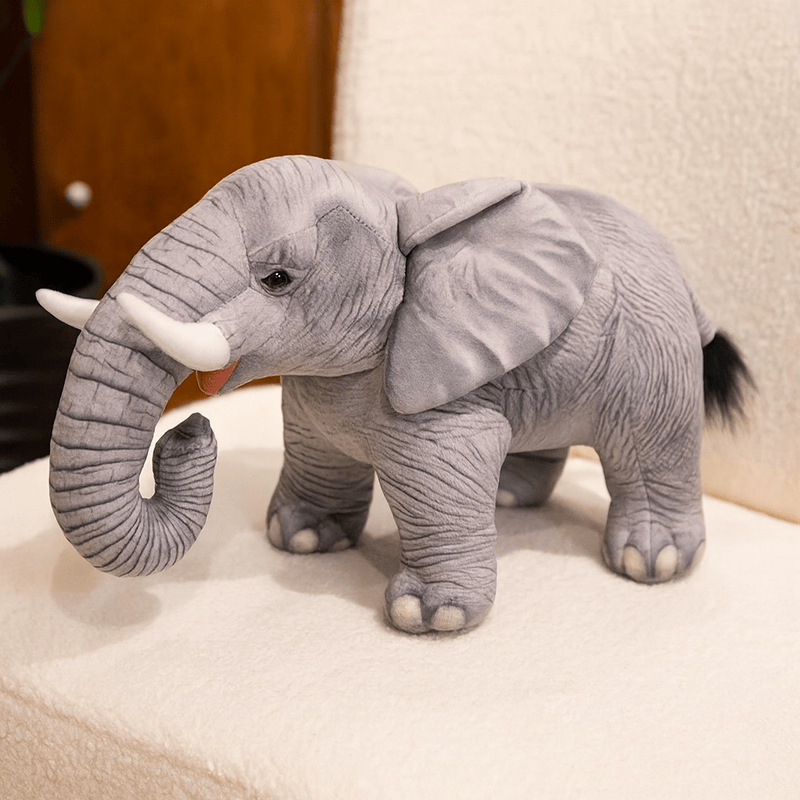 Grande peluche éléphant gris réaliste sur une chaise