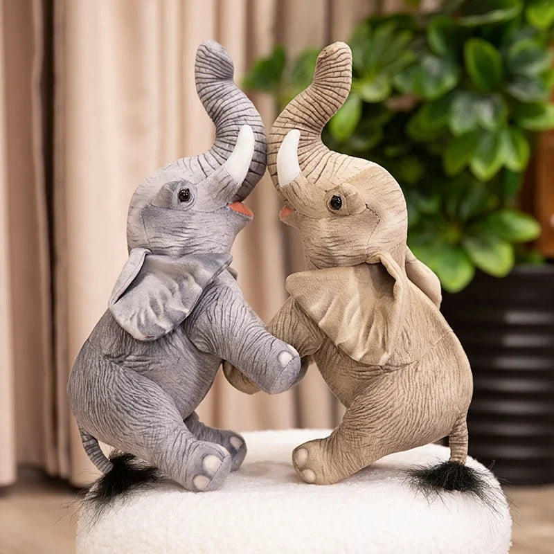 Deux petites peluches éléphants grise & marron étant accolé par les trompes debout