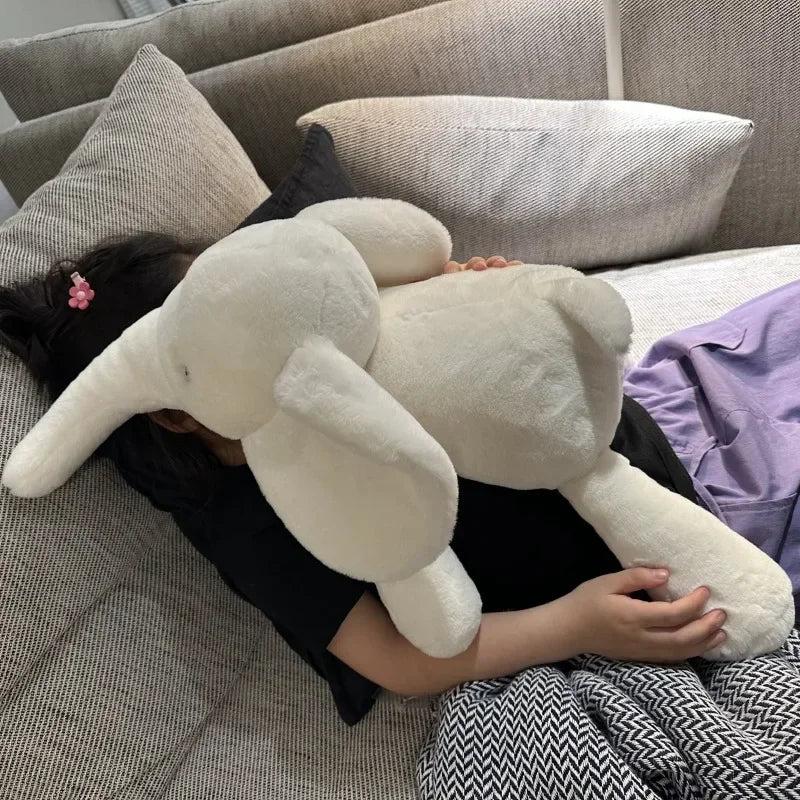 Peluche éléphant blanche super douce posée sur une fille sur un canapé Image