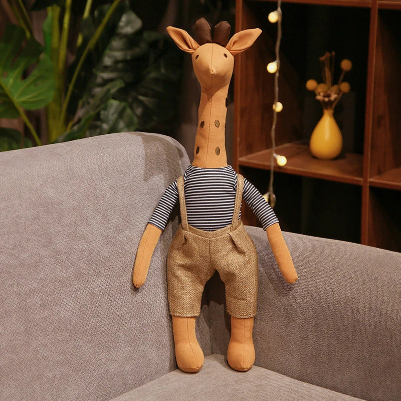 Peluche girafe habillée en brun sur un canapé