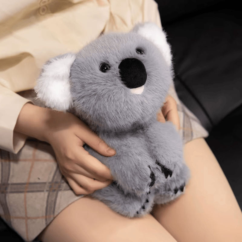 Peluche koala kawaii assis sur les genoux d'une fille Image