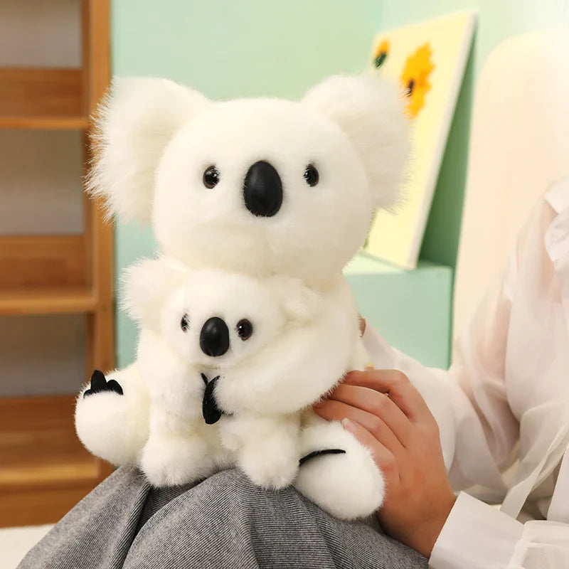 Peluche koala blanc mère et fils sur le genou d'une femme