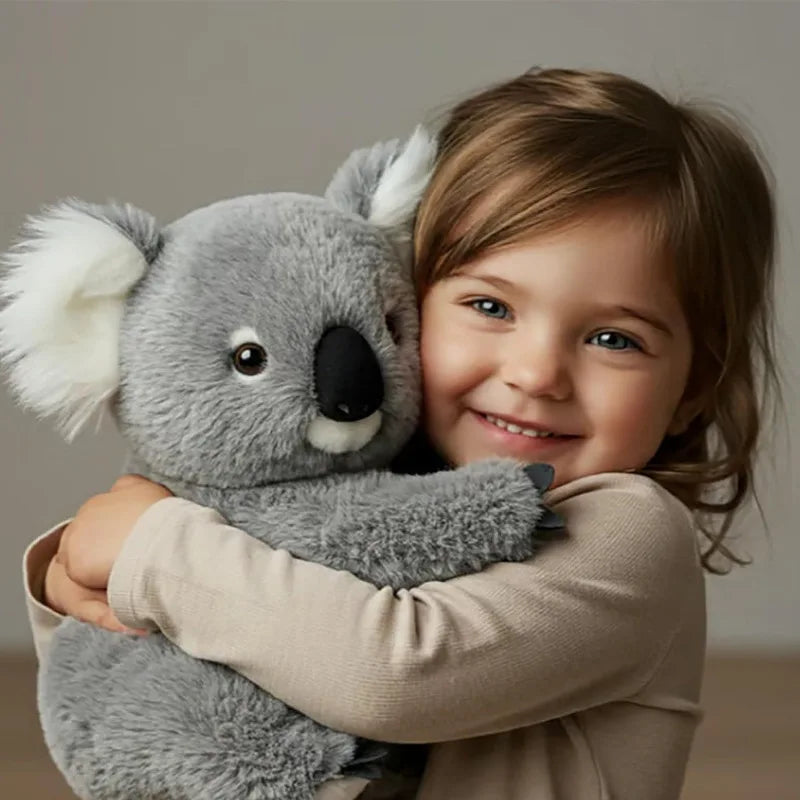 Peluche koala réaliste dans les bras d'un enfant Image