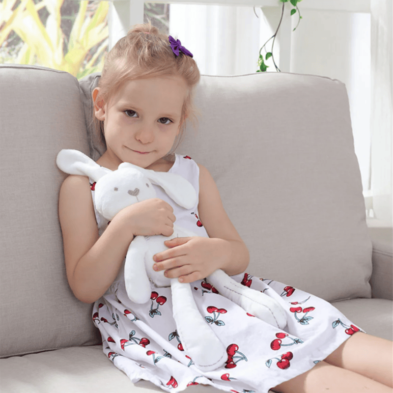 Peluche lapin compagnon de couchage, couché sur une fille  Image