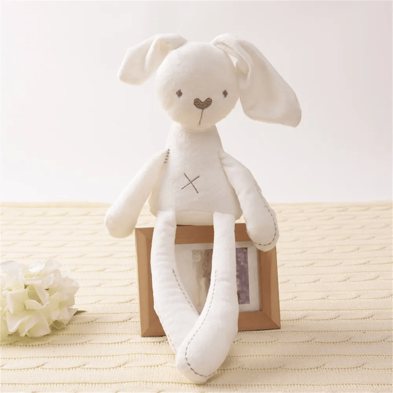Peluche lapin compagnon de couchage assis sur un cadre de photo