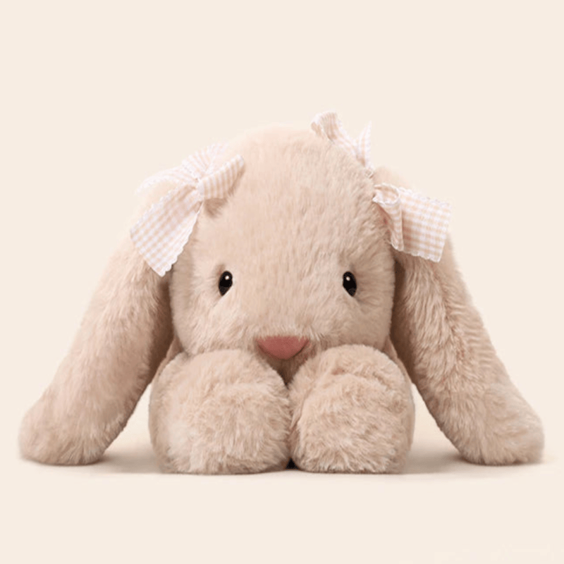 Peluche lapin couché de face sur un fond blanc