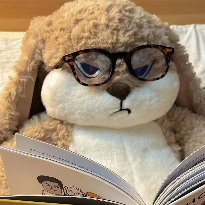 Peluche lapin en colère avec ses lunettes en lisant un livre  Image