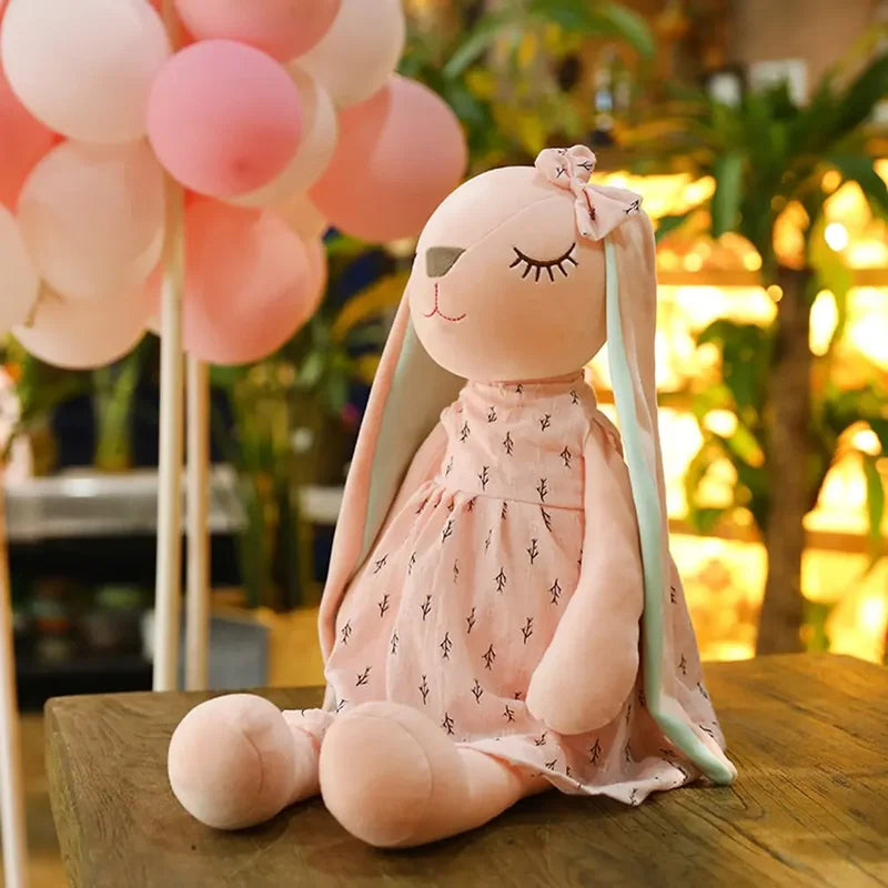Peluche lapin rose endormi sur une table